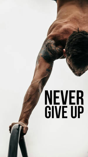 一個有紋身的肌肉男做引體上升，並有文字 never give up。