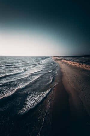 暮色中，海浪輕輕拍打沙灘。