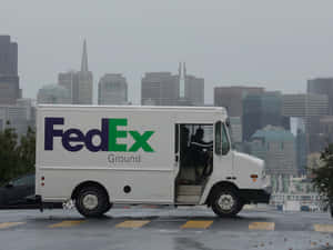 FedEx貨車停泊在雨天城市，背景有天際線