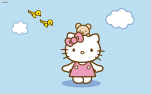 Hello Kitty 頭上頂著泰迪熊，在藍天白雲和飛鳥的天空下。