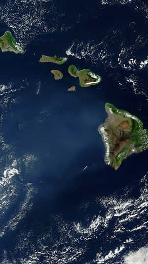 海洋中火山島的衛星圖像，有綠色森林和白色雲朵。