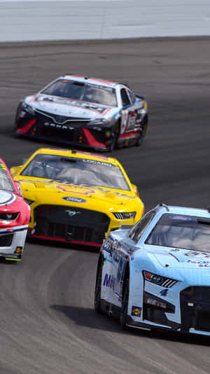 三輛NASCAR賽車在日落時分的賽道上緊密競速。