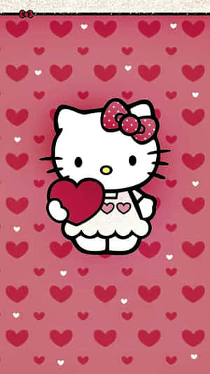 Hello Kitty 在心形圖案的粉紅色背景上手持一顆心。