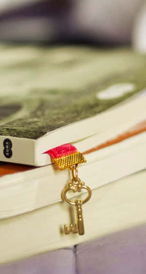 金色鑰匙書籤，帶紅色絲帶，置於書脊上。 — 可愛少女風gif 壁紙