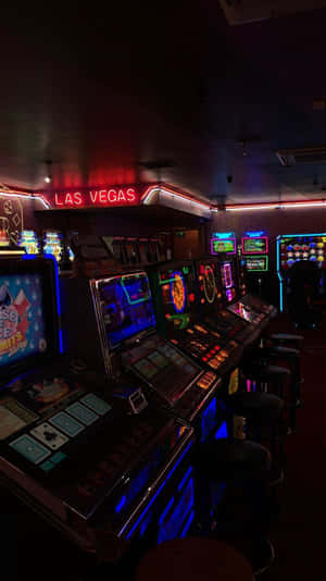 在賭場 'LAS VEGAS' 標誌下，色彩繽紛的霓虹燈照亮角子機。