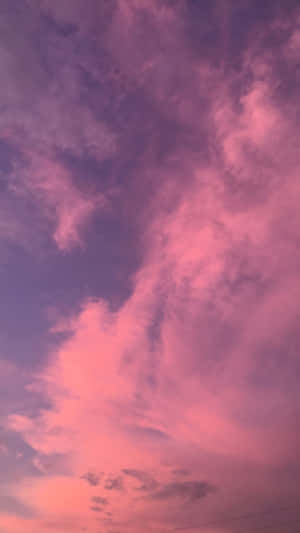粉紅色和紫色的雲彩在黃昏的天空中翻騰。 — iPhone 粉紅美學 壁紙