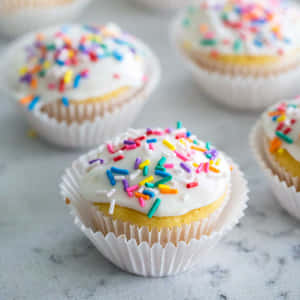 彩色糖針 cupcake 配白色糖霜，放在大理石檯面上的特寫。