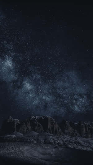 星空夜空，銀河在黑暗山脈剪影之上。