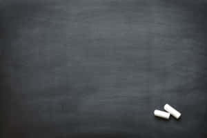 深灰色黑板表面上的兩支白色粉筆。