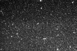 一個充滿無數閃爍星星的星空夜空，背景為黑色。 — 銀色 壁紙