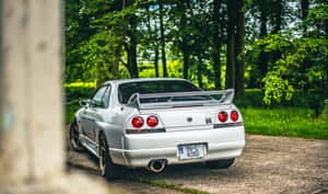 森林中碎石路上停泊的銀色日產Skyline GT-R。 — 汽車 壁紙
