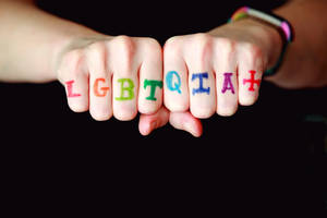 兩個拳頭，指節上有彩虹色的LGBTQIA+。
