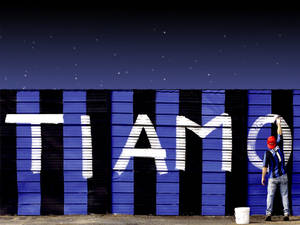 粉絲在星空下於間條牆上噴上「TIAMO」。