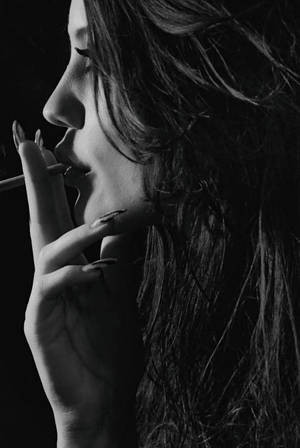 黑白肖像中抽煙的女性，帶有戲劇性燈光。