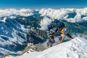 登山者在雲海上攀登積雪的山脊。