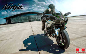 電單車手在機場上騎著 Kawasaki Ninja 傾斜入彎。