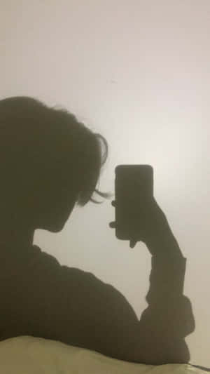 喺昏暗房間用電話自拍嘅人。