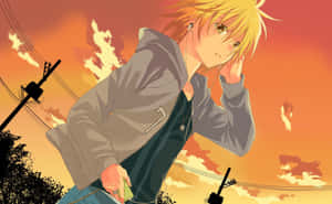 金發動漫男孩在夕陽下穿著灰色連帽衫聽音樂。