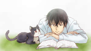 年輕男子與黑白貓在草地上看書