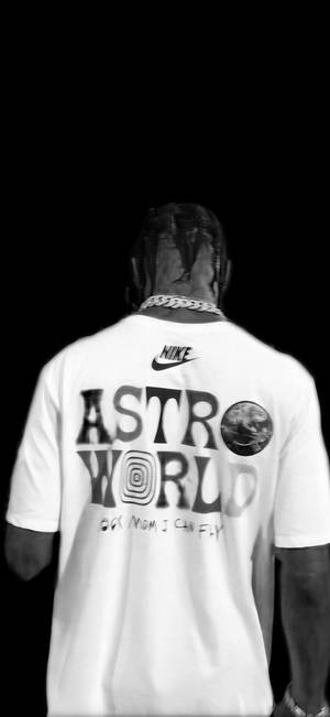 穿著白色Nike Astro World T恤的人從背後觀看，背景為黑色。
