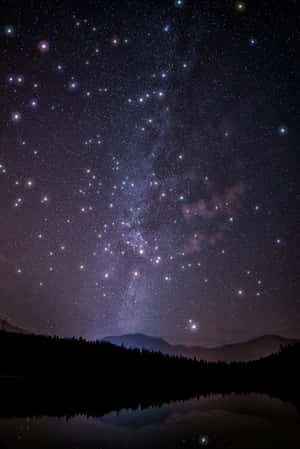 星空夜景，銀河橫跨山脈和湖面倒影
