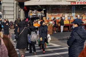 人群在陽光明媚的日子裡在水果市場附近過馬路
