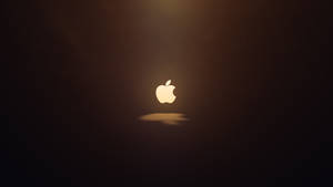 發光的Apple標誌在黑暗空間中置中，帶有柔和光線。
