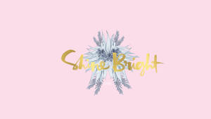 粉紅色背景上的金色Shine Bright文字與銀色松樹枝