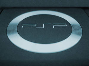 深色遊戲機表面上的發光PSP標誌特寫。 — PlayStation GIF 壁紙