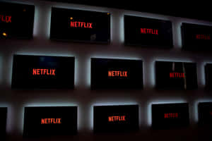 在黑暗的房間中，帶有藍色背光的 Netflix 螢幕牆發光。