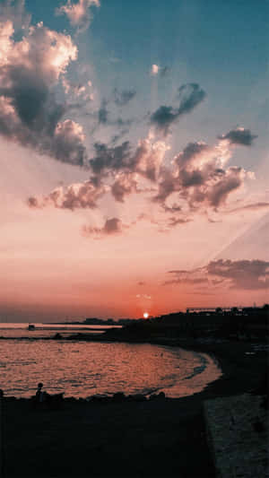 平靜海岸灣的日落，有粉紅色的雲彩和剪影般的懸崖。
