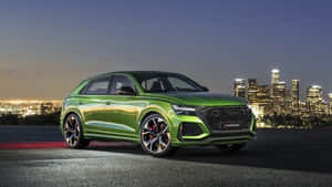 綠色Audi SQ8 Sportback停在山坡上，俯瞰夜晚燈火通明的城市。