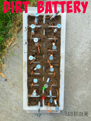 DIY泥土電池實驗，螺絲和電線在塑膠托盤中發光。