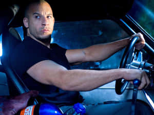 一個男人在賽車裡，在藍光下握著方向盤。 — 荷里活 GIF 壁紙