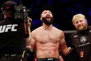UFC拳手與工作人員及攝製組在八角籠內慶祝勝利。