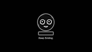 一個發光的黑色笑臉，有白色眼睛和嘴巴，下方有文字 Keep Smiling。 — 微笑 壁紙
