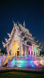 星空下被彩虹燈光照亮的白色寺廟