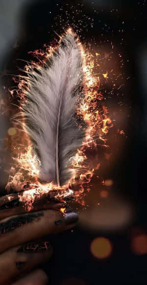 手裡拿著一根燃燒的羽毛，火花在黑暗中飛舞。