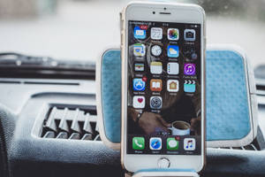 藍色車載支架中的iPhone，屏幕上顯示應用程式圖標