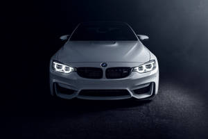在黑暗攝影棚環境中，白色BMW跑車車頭燈閃爍。 — 寶馬 iPhone 壁紙
