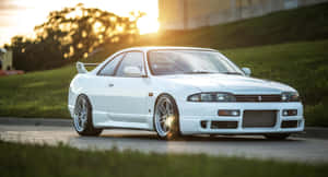 白色日產Skyline R32跑車在金色夕陽下停靠在路邊。 — 汽車 壁紙