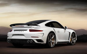 白色保時捷911 Turbo S Stinger在日落時分的沙漠公路上。