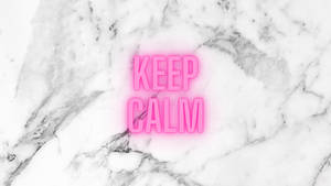 粉紅色霓虹燈牌，上面寫着 'KEEP CALM'，置於大理石表面。
