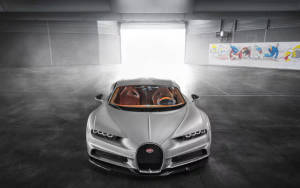 銀色Bugatti Chiron喺現代工業風車庫中，帶有強烈背光。