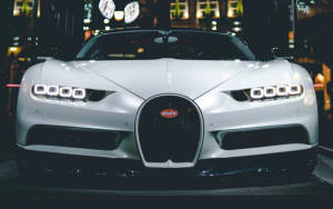 銀色Bugatti Chiron跑車在黑暗的車庫中被霓虹燈照亮。
