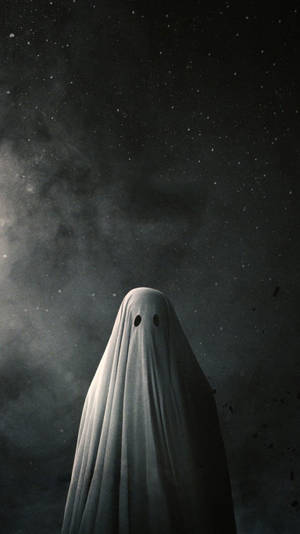 一個有眼孔的鬼影，站在星空夜空下。