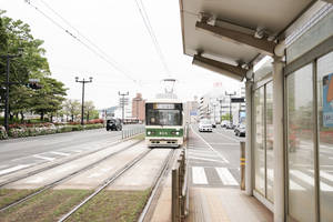 綠色和白色的電車抵達現代化的城市車站月台。