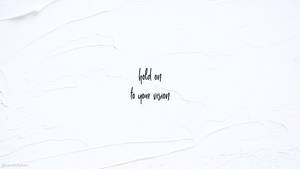 白色紋理牆，帶有黑色草書引文 hold on to your vision