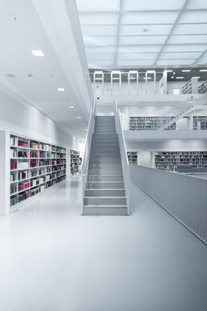 一個現代白色圖書館，設有書架和中央樓梯。