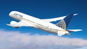 聯合航空噴射機在晴朗藍天的雲層上方飛行